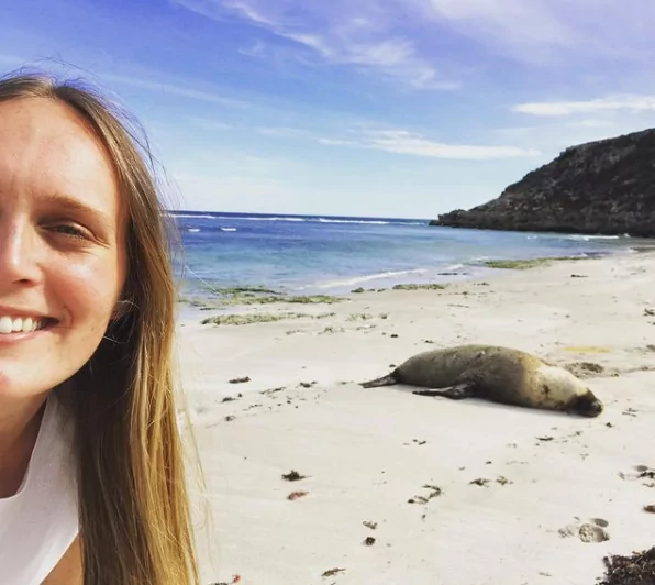 Dr. Chloe Buiting on a beach with sea lion - I Love Veterinary