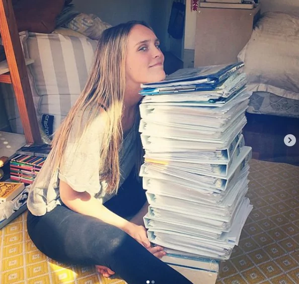 Dr. Chloe Buiting with the pile of books while she was on her studies - I Love Veterinary
