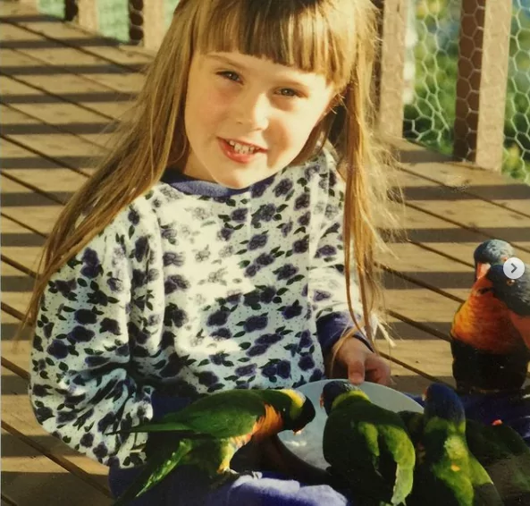 Dr. Chloe Buiting as a child feeding parrots - I Love Veterinary
