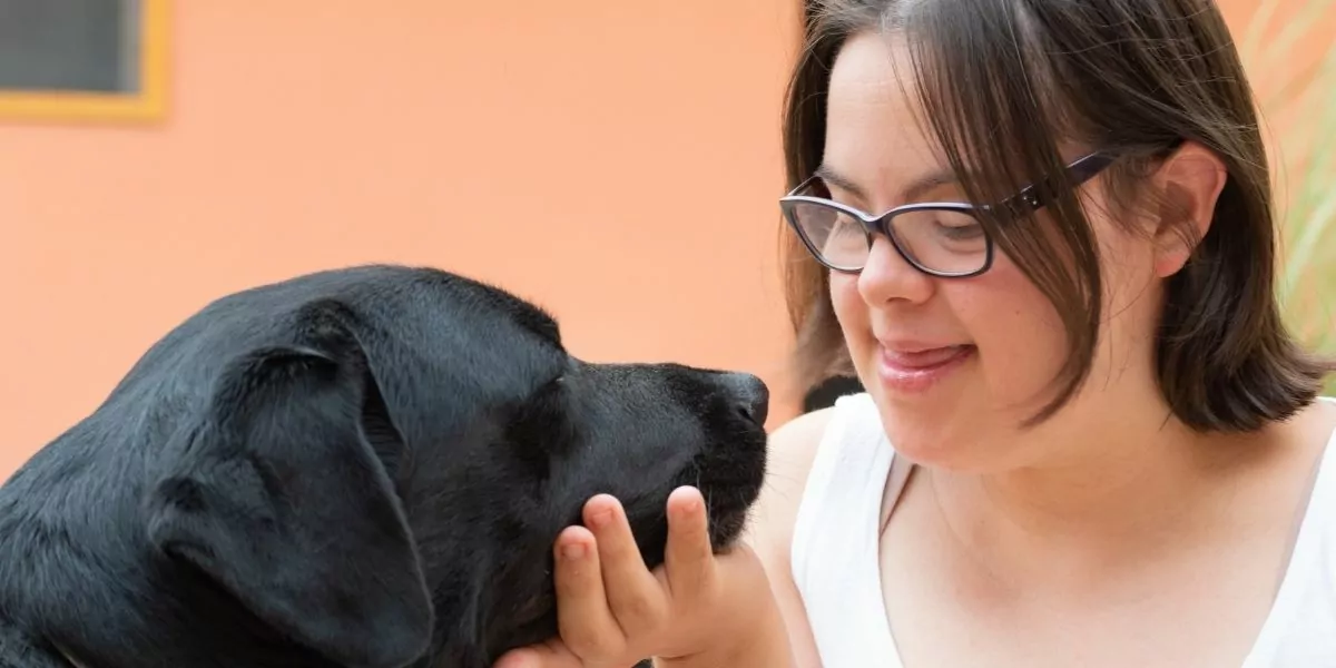 human with down syndrome petting a dog