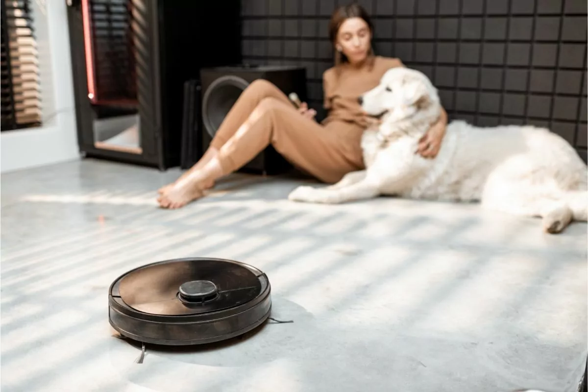 Robot Vacuum Cleaner near Woman and Pet Dog