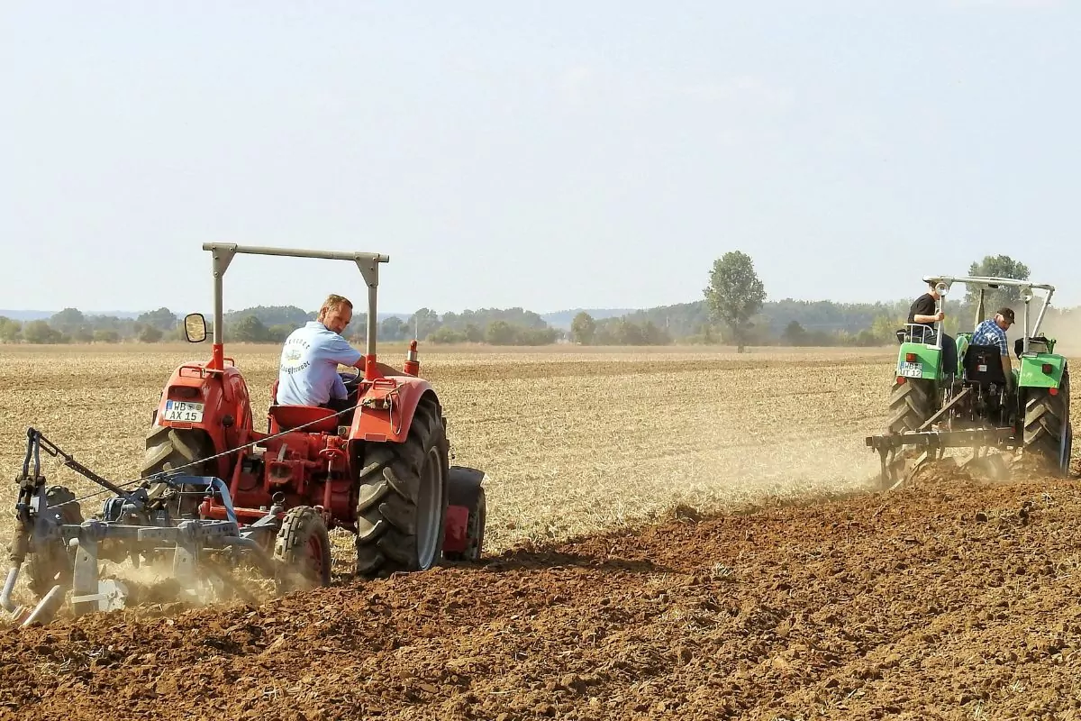 farmers on tractors plowing fields