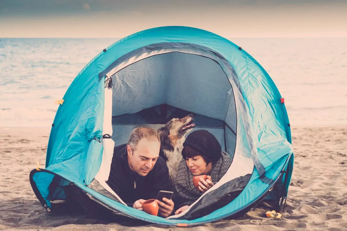 Couple inside tent with dog