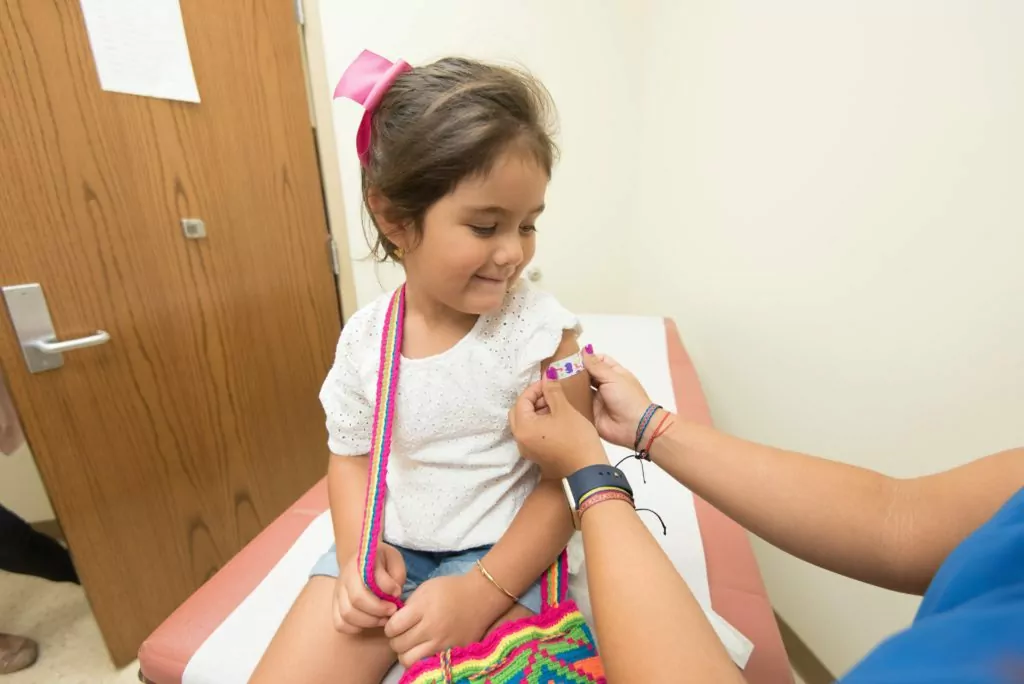 little girl getting a band aid after receiving a vaccine